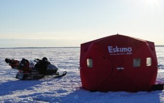ice fishing shack and snowmobile