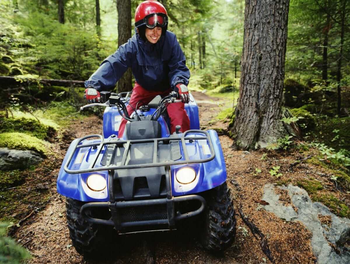 A grinning adventurer prepares to take her next turn during a rugged ATV tour in Manitoba.
