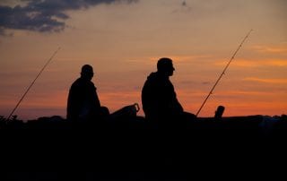 Two anglers enjoy fishing in Manitoba during sunset at Bakers Narrows Lodge.