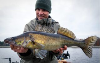 A happy angler smiles at large fall walleye he caught during the Manitoba fishing season at Baker's Narrow Lodge.
