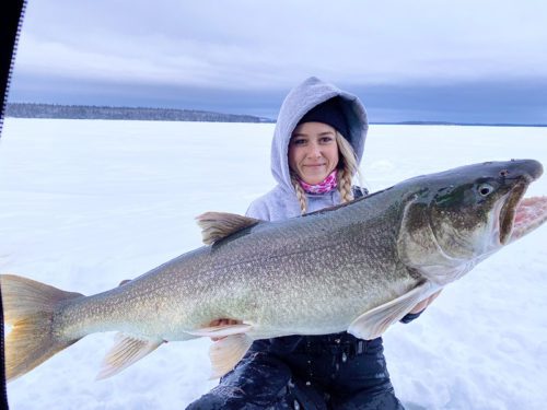 A young female ice angler shows off a large fish she caught during a girls weekend getaway near Flin Flon, MB.