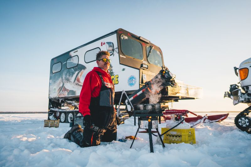 Ice Fishing Canada: An ice angler cooks his catch on frozen Lake Athapapuskow. 