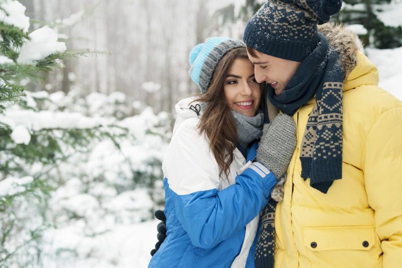 Couples Getaway Manitoba: A young couple embrace during a romantic winter getaway in Northern Manitoba's Bakers Narrows Lodge.