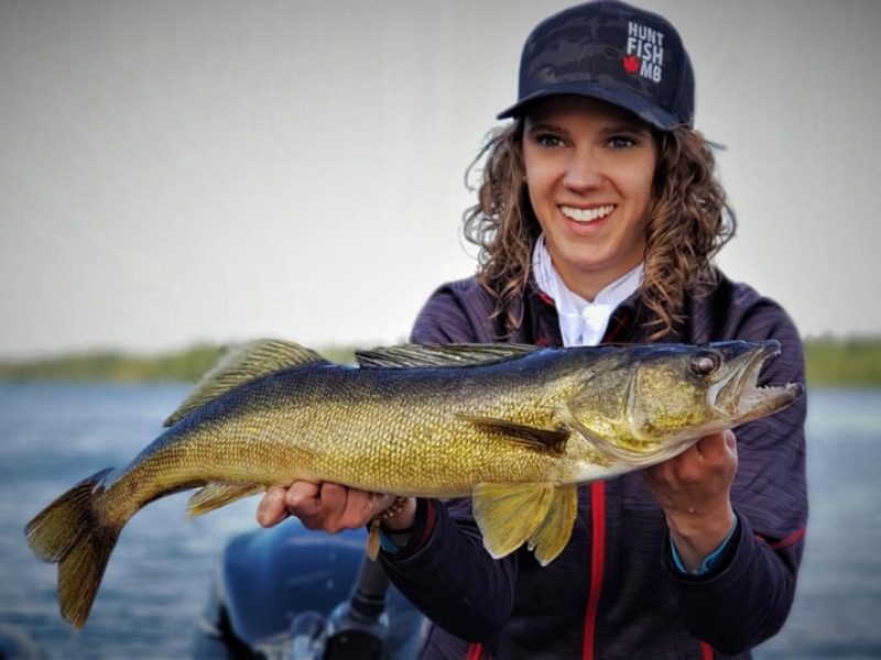 Fishing for Walleye: A young woman smiles as she holds a nice sized walleye during her Northern Manitoba fishing trip.